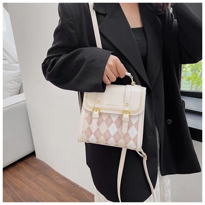Close-up of pink and cream diamond pattern PU leather bag with golden buckle and rivet details