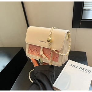Detail of cream leather crossbody bag with pink woven texture and gold chain strap