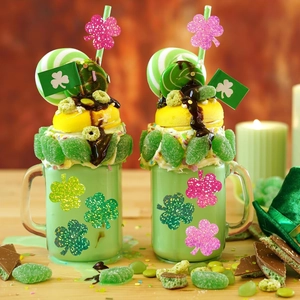Close-up of holographic clover stickers decorating festive drinks for St. Patrick's Day
