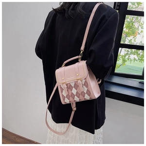 Close-up of quilted heart-pattern mini backpack with pink contrast and metal buckle detail