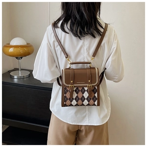 Detail of argyle pattern and brown leather straps on a versatile mini backpack for women