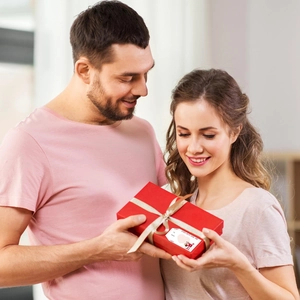Detail van rode geschenkdoos met champagne lint en Love Is In The Air zelfklevend etiket