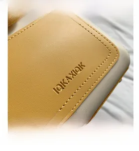 Gros plan sur la texture du cuir grainé et les coutures de précision du sac seau