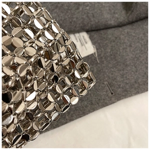 Macro shot of silver metallic sequin chainmail texture on a stylish luxury shoulder bag