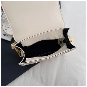 Internal view of cream-white backpack showing black lining and gold metal zipper detail