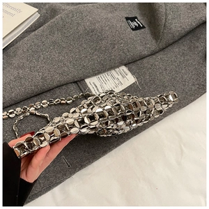 Detail of silver metal hollow mesh bag with polished chain strap and round metallic discs