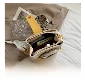Vue de dessus de l'intérieur du sac crème et jaune montrant sa grande capacité de rangement