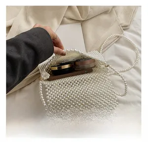 Interior view of white pearl handbag showing storage for phone, lipstick, and cosmetics