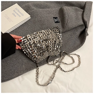 Close-up of silver metal disc woven shoulder bag with polished mirror finish texture