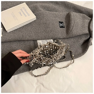 Detail of silver metallic hollow-out chain bag on gray wool coat in a stylish setting