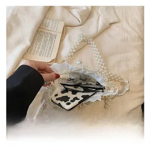 Internal view of handmade pearl beaded crossbody bag showing phone and accessories storage