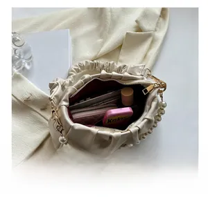 Detail view of large interior capacity for white pleated cloud bag with pearl handle