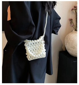 Detail of elegant handmade pearl woven mini bag with crossbody strap on a model