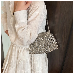 Detail view of silver metal paillette weaving on crossbody bag with mirror finish texture