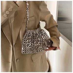 Detail of silver metallic woven shoulder bag with hollow mesh design and beaded texture