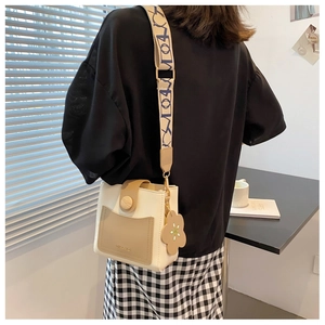 Détail du sac seau bicolore crème et marron avec bandoulière jacquard et fleur