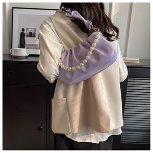 Detail of purple ruched cloud bag featuring pearl chain and soft pleated shoulder strap