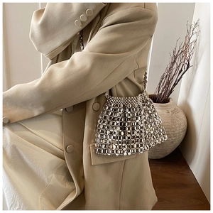 Detail view of a silver metallic paillette woven bag with an intricate hollow mesh structure
