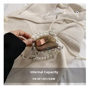 Detailed view showing internal capacity of the pearl beaded mini crossbody handbag