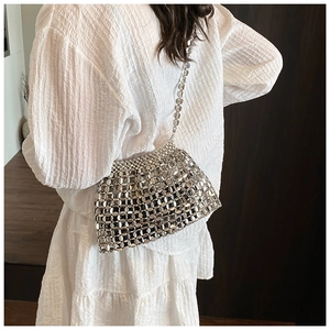 Detailed view of silver sequin metal chainmesh bag on model wearing white dress