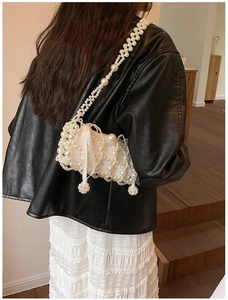 Detailed view of pearl beaded mini crossbody bag with long white silk ribbon detail