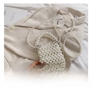 Detail showing hand-woven white pearl texture and handle on a mini crossbody bag