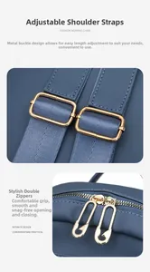 Detail of adjustable woven shoulder strap and golden safety pin zipper on a navy backpack