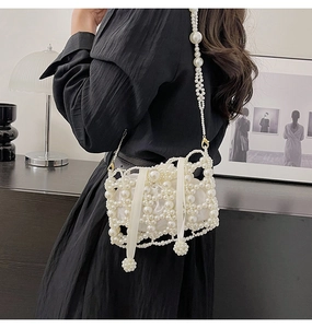 Detailed view of woven pearl bucket bag with satin drawstring liner and bead charms