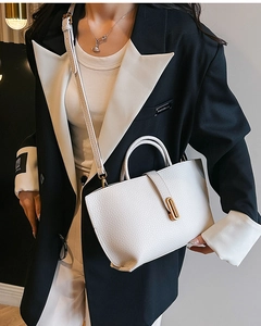 Close-up of white lychee pattern leather bucket bag with elegant gold twist lock clasp