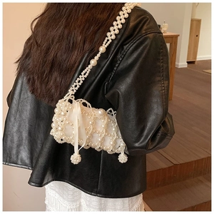 Crossbody pearl bag with woven beads and a satin ribbon bow detail on leather jacket