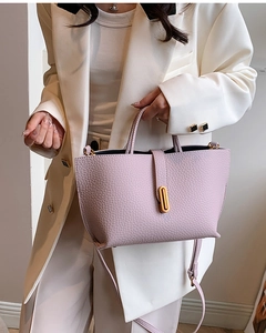 Close-up of lilac lychee texture leather tote with elegant gold oval metal lock buckle