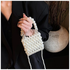 Detailed view of mini pearl beaded handbag with metallic rings and shoulder strap