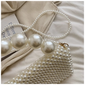 Detailed macro view of handmade woven faux pearl handbag texture and large pearl handle