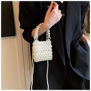 Detail of elegant white pearl beaded mini handbag featuring hand-woven design and pearl chain