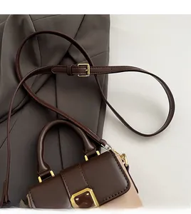 Détails de la bandoulière en cuir réglable et finitions dorées du sac à main bicolore