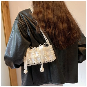 Detail of beaded pearl handbag with satin drawstring lining and elegant shoulder strap