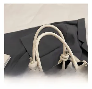 Detail van wit generfd lederen handvat met decoratieve knoop en zilveren gesp