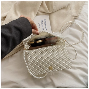 Detail view of pearl beaded handbag interior showing phone and makeup storage capacity