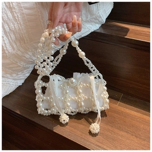 Detail of beaded pearl handbag with satin drawstring lining and woven pearl exterior