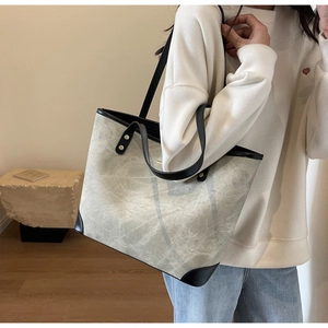 Detailed shot of large tote bag with grey marble texture and black leather trim
