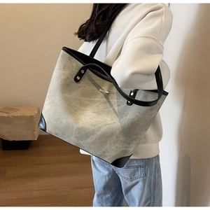 Detail of grey marble pattern tote bag with black leather corners and gold studs