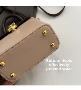 Détail du fond du sac avec quatre clous de protection dorés et coutures précises
