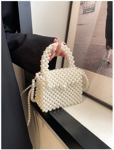 Detailaufnahme der handgefertigten weißen Perltasche mit rundem Griff und Schultergurt