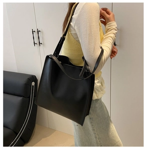 Practical look of the large black minimalist tote bag worn as an underarm shoulder bag
