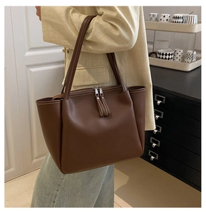 Detail of vintage large brown tote bag with contrast white stitching and dual zippers