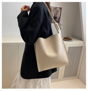 Detail showing high-quality cream white tote bag with neat stitching on office outfit