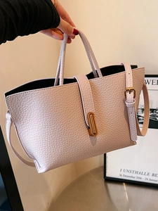Light pink pebbled leather tote bag with gold oval lock and adjustable shoulder strap