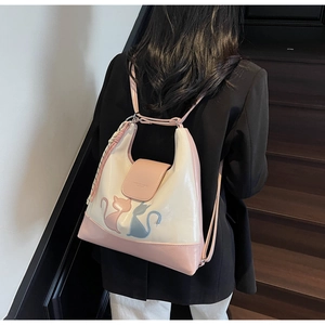 Detail of pink and white patent leather bag with cat silhouette patterns and a flap closure