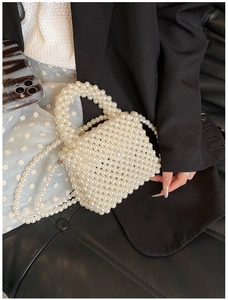 Detail der handgefertigten weißen Perltasche mit langer Kette und edlem Perlen-Griff