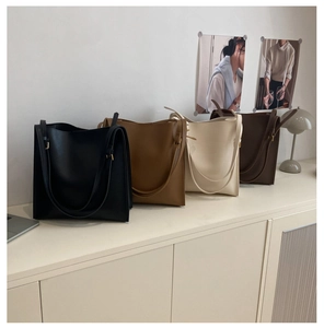 Detailed display of four soft leather tote bags in black, camel, beige, and dark brown colors